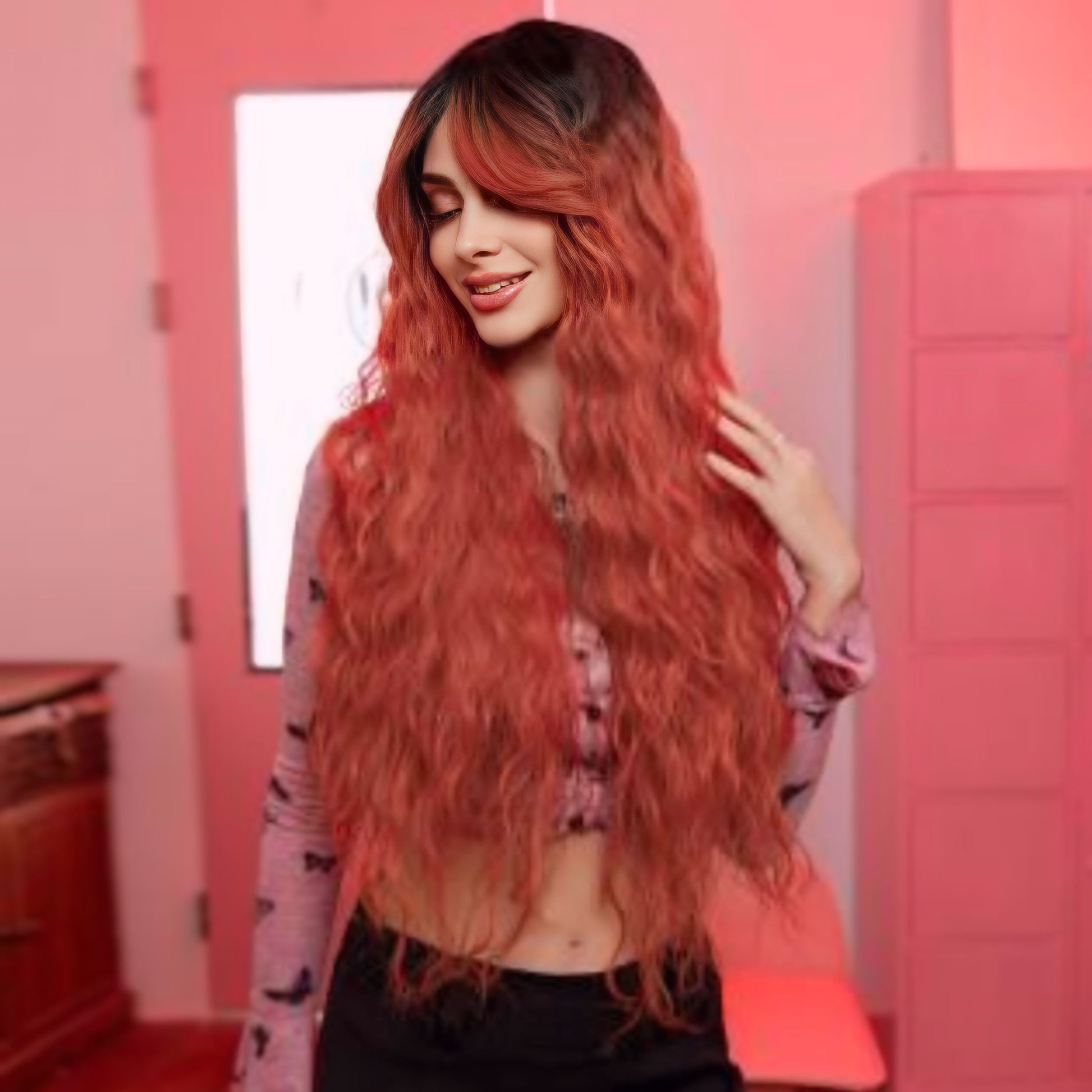 Heat-resistant synthetic wig in coral wavy style, designed with bangs and a comfortable, adjustable cap.