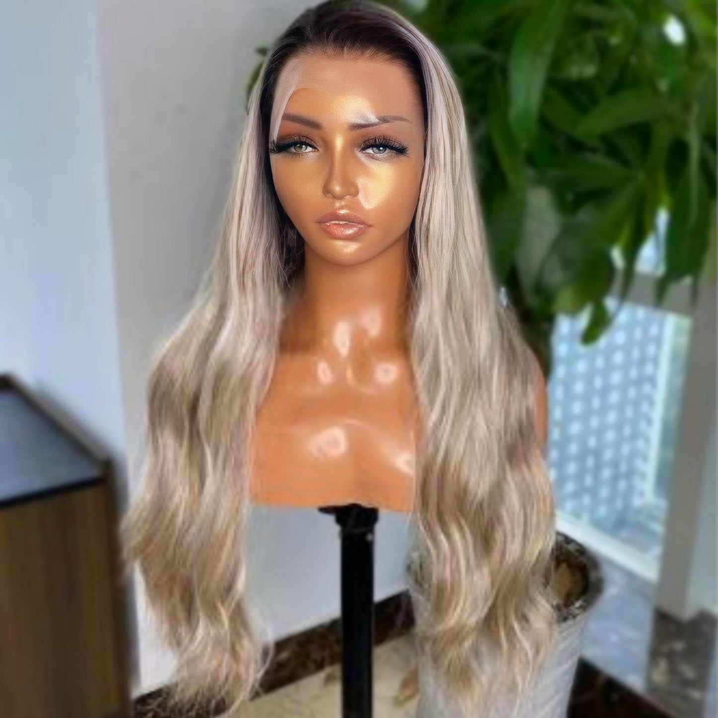 Model wearing a Rooted Ash Blonde Lace Front Synthetic Wig, showcasing realistic wavy texture and natural hairline.
